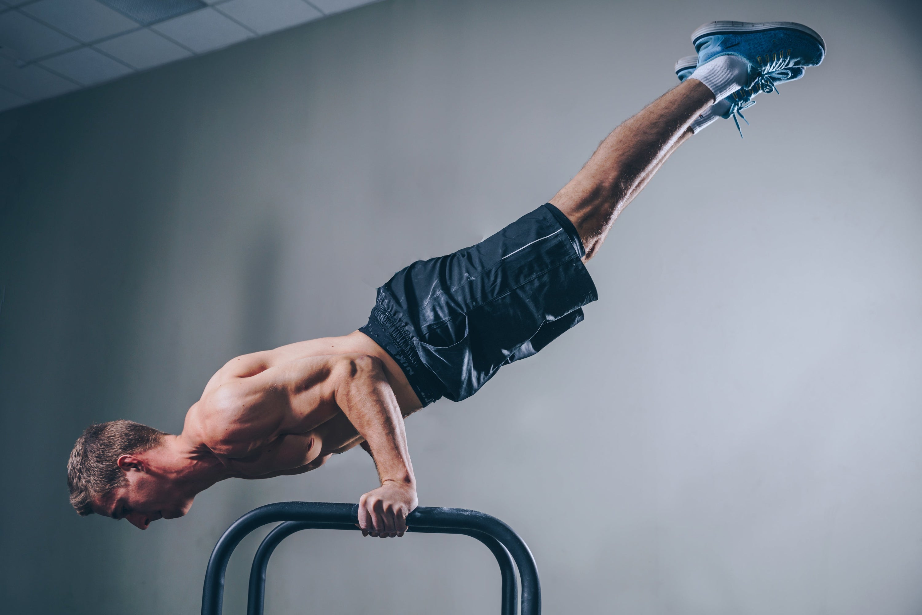 A fitness enthusiast demonstrating an effective circuit training session on parallel bars.
